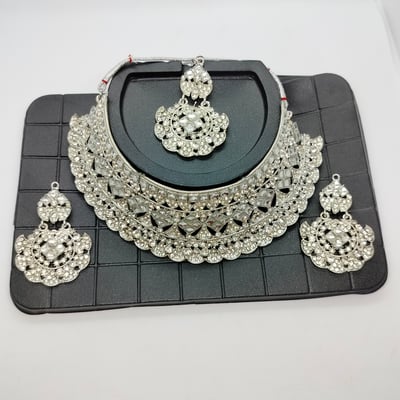 silver necklace set earrings and a maang tikka